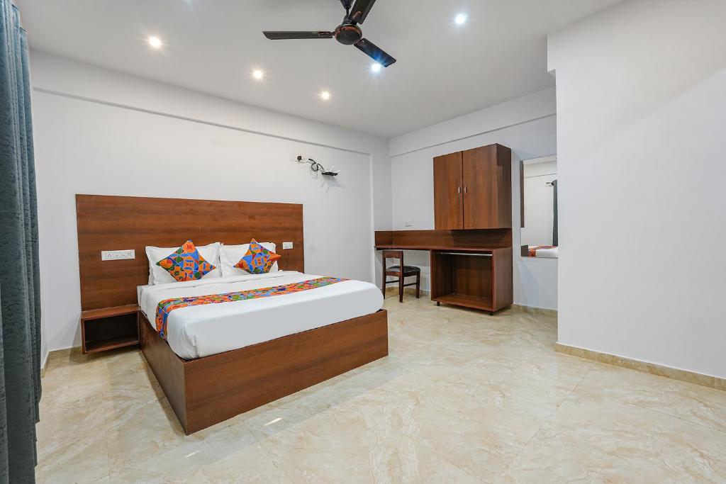a bedroom with a bed and a desk in it at FabHotel Tree Suites in Bangalore