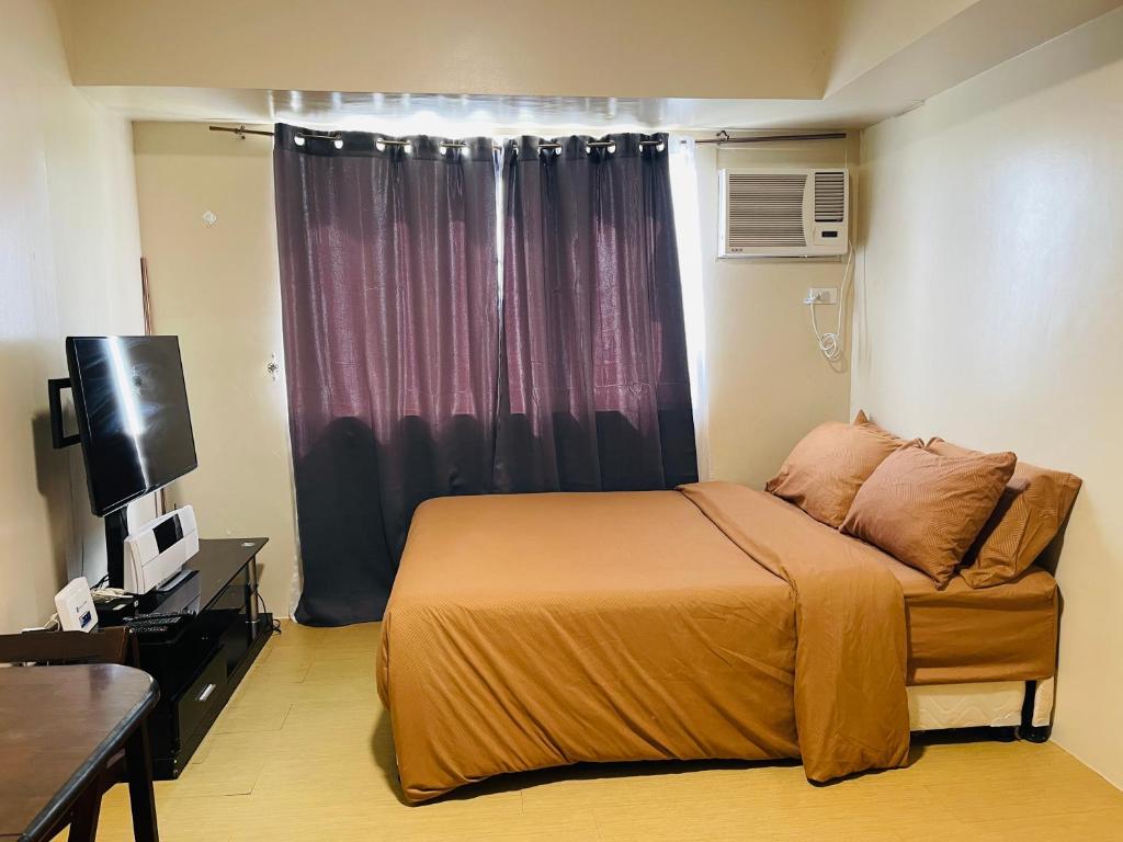 - une chambre avec un lit, une télévision et une fenêtre dans l'établissement * * G Best value for the price!, à Iloilo