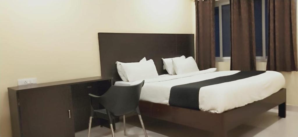 1 dormitorio con 1 cama grande y 1 silla en Arvind Stay Hotel, RK Beach Vizag, en Visakhapatnam