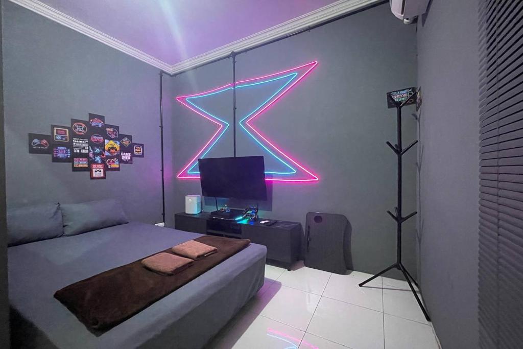 een slaapkamer met een bed met een neonbord aan de muur bij Treebox in Ngadipuro