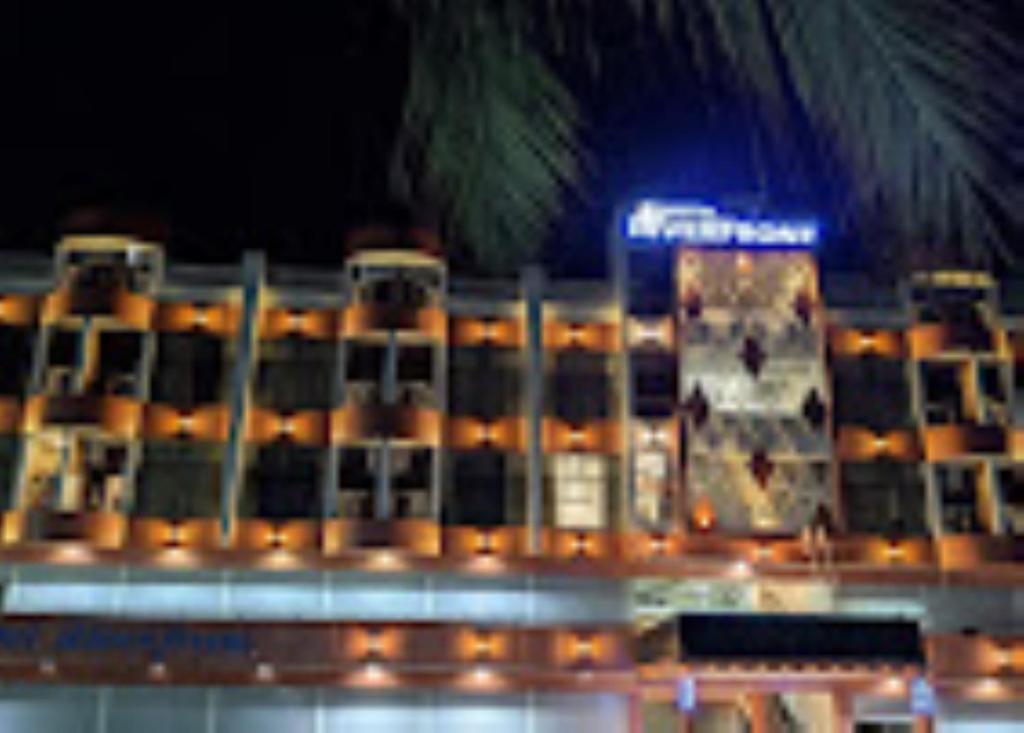 a large building with lights in front of it at Hotel Riverfront , Prabhas Patan in Somnath