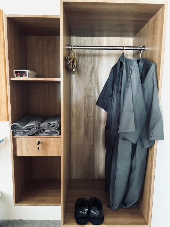 a closet with a robe and shoes in it at Uma Pantai Seseh in Canggu