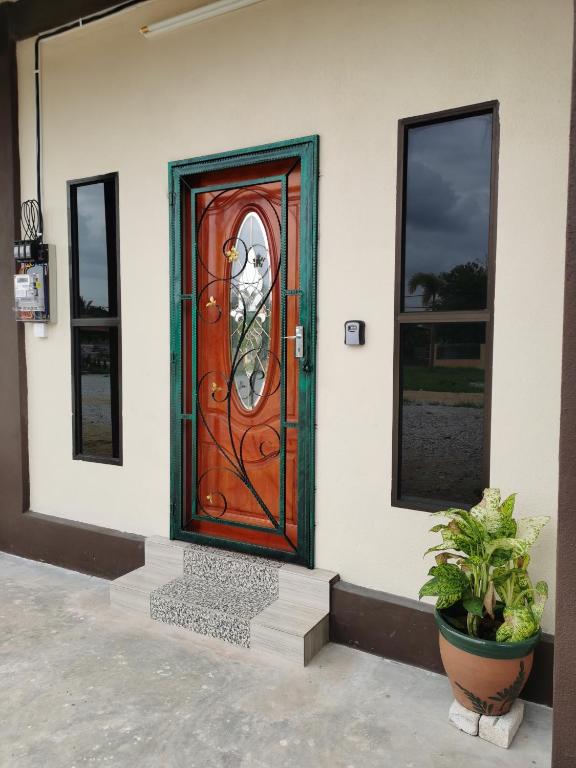 a wooden door on a building with two windows at Villa Tok Wan in Kuantan