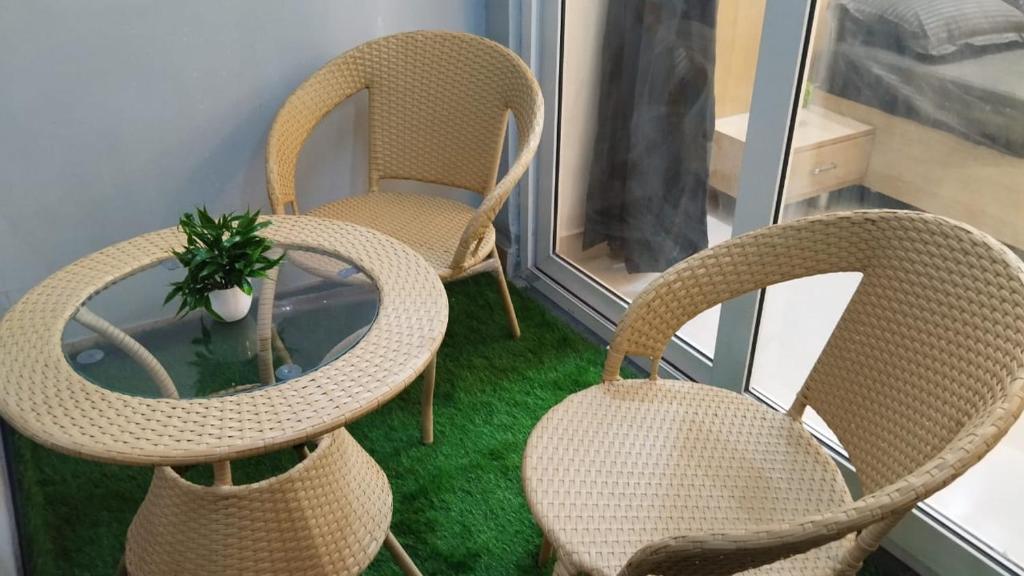 2 chaises en osier et une plante en pot dans une pièce dans l'établissement LPW Studio Apartment, à Greater Noida