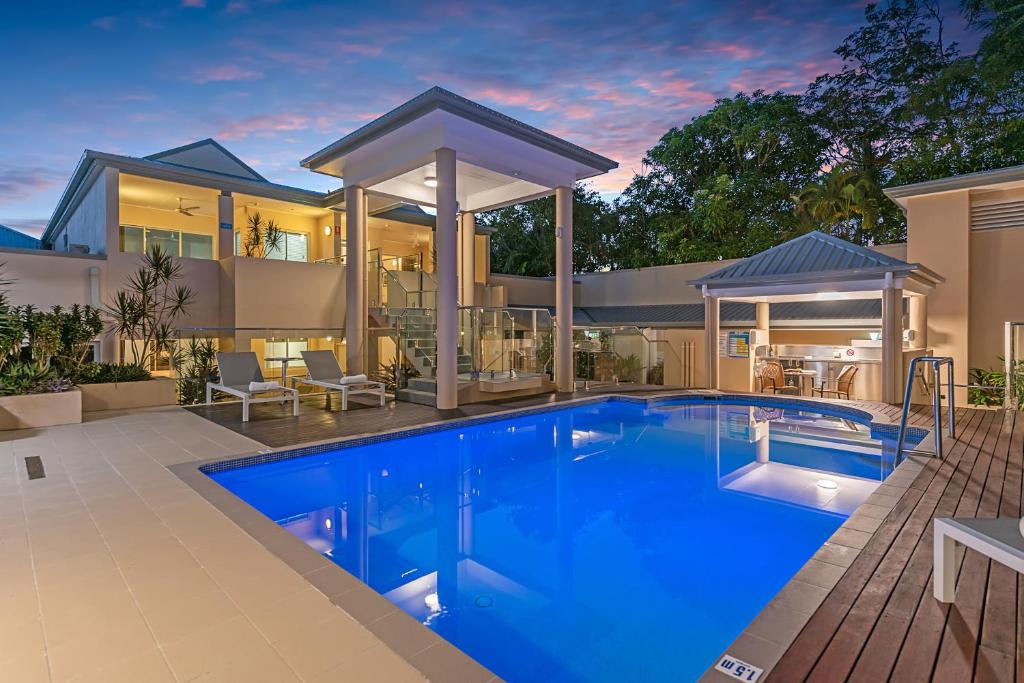 a house with a swimming pool in front of a house at The Newport on Macrossan - Adults Only in Port Douglas