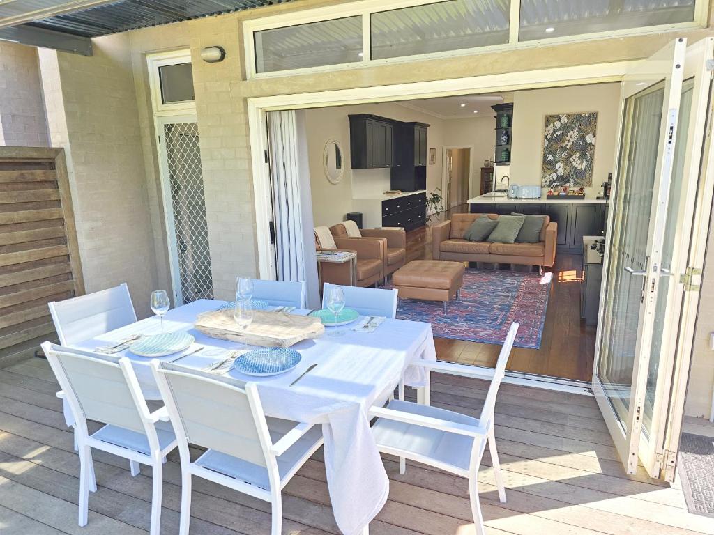a white table with white chairs and a living room at New: Araluen, Heart of Bowral in Bowral