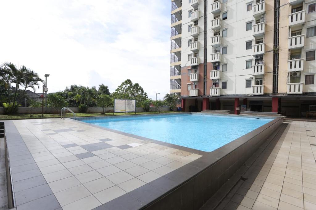 una grande piscina di fronte a un edificio di OYO 93585 Apartemen Cibubur Village By Raja Property a Depok