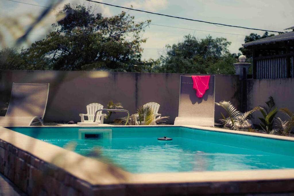 a swimming pool in a backyard with a pink shirt on a fence at Trou aux Biches Serenity in Pointe aux Biches