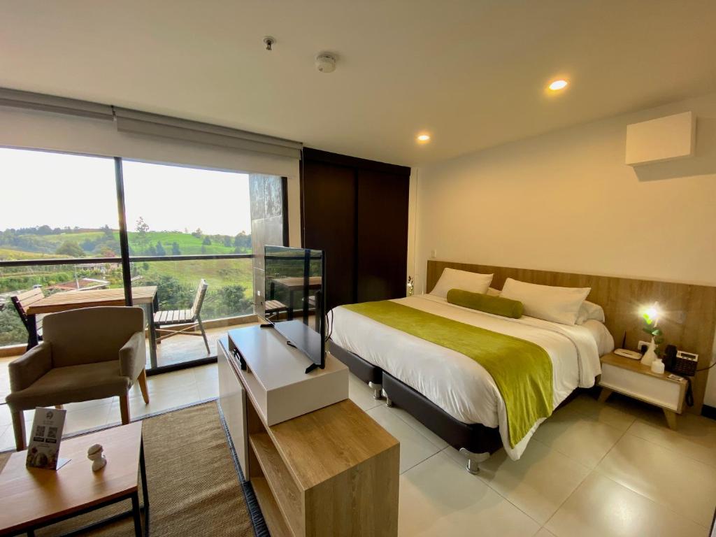 1 dormitorio con cama y ventana grande en Room in Studio - Suite hotelera - A 5 minutos del Aeropuerto, en San Antonio de Pereira