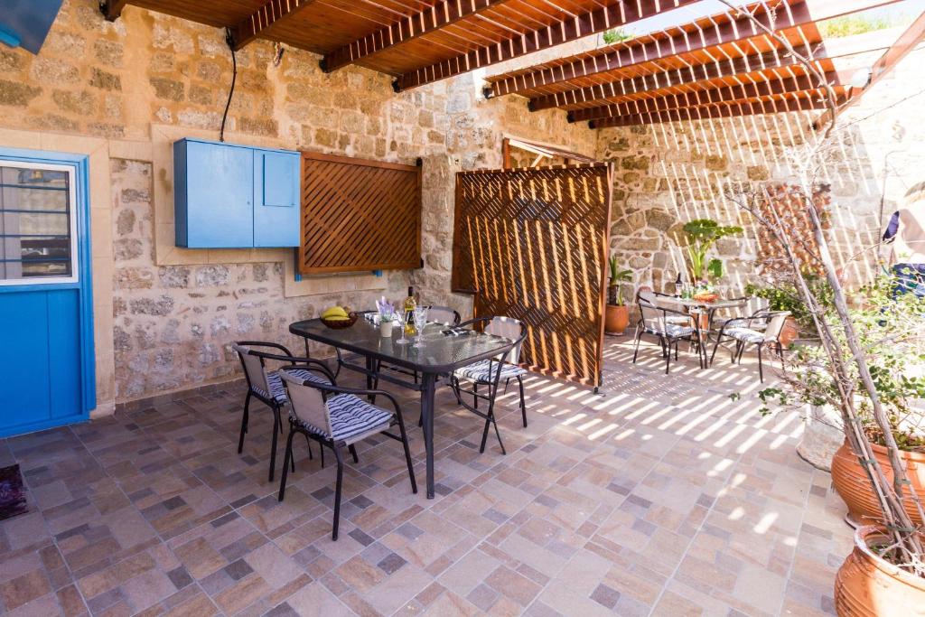 a patio with a table and chairs and a tv at Galini Apartments Old Town in Rhodes Town