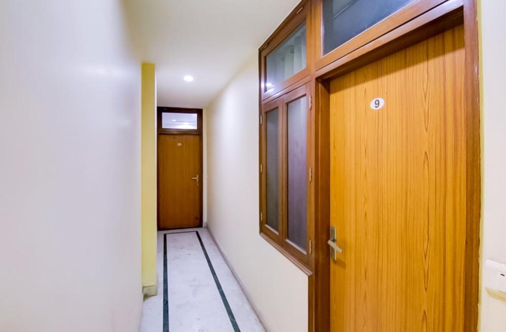 a hallway with a wooden door and a window at Hotel shayam in New Delhi