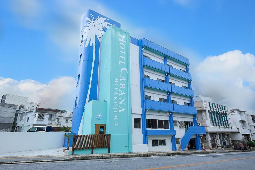 a blue building with a palm tree on it at Hotel CABANA カバナ 宮古島 in Miyako Island