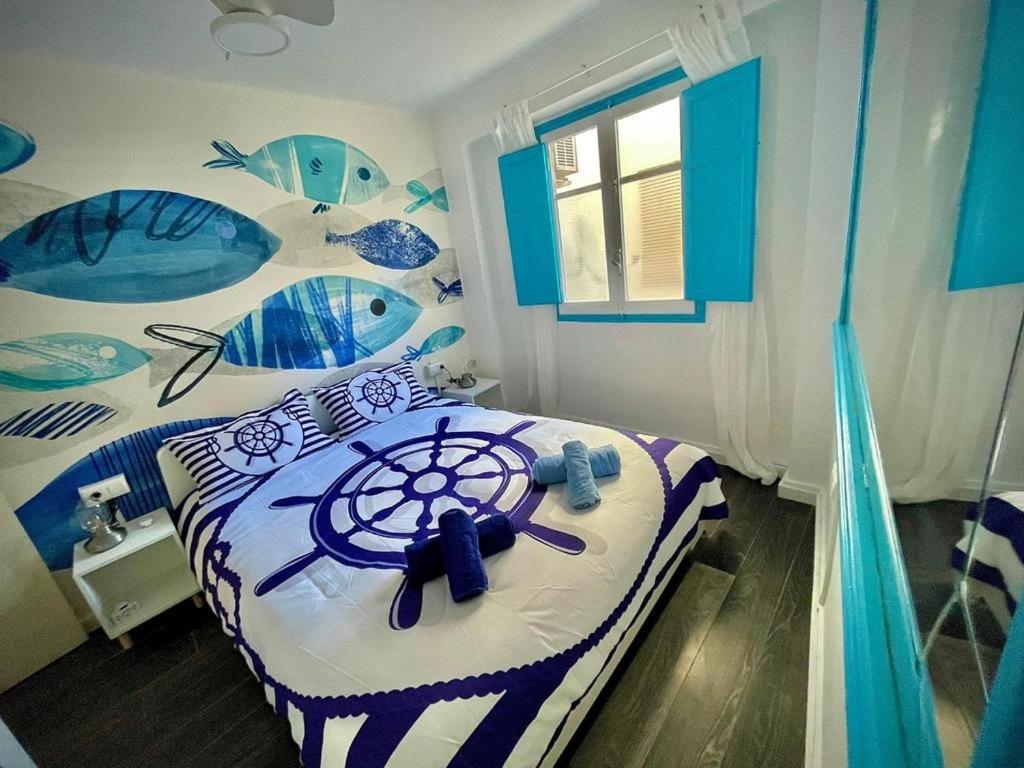 een slaapkamer met een bed met een blauwe en witte sprei bij Sailor Apartment nel Cabanyal in Valencia