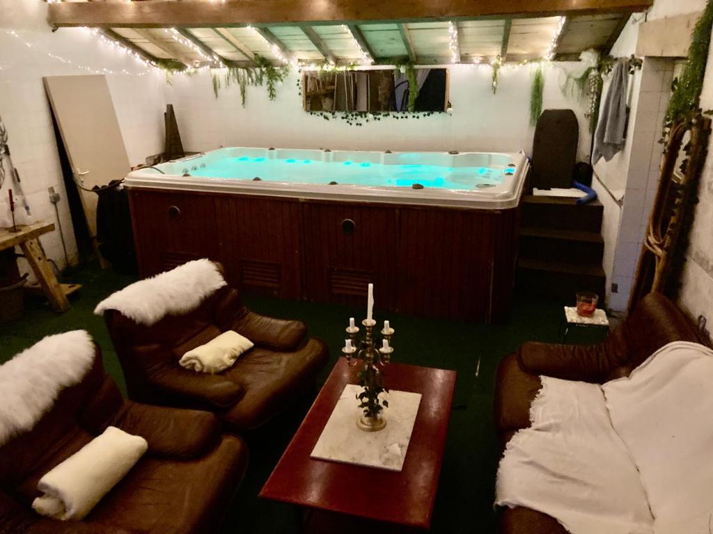 - un bain à remous dans une pièce avec des canapés et une table dans l'établissement Cottage River & Spa, à Saint-Ilpize
