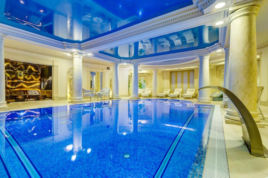 a large swimming pool in a large room with a large building at Pałacyk Otrębusy Business & Spa in Otrębusy