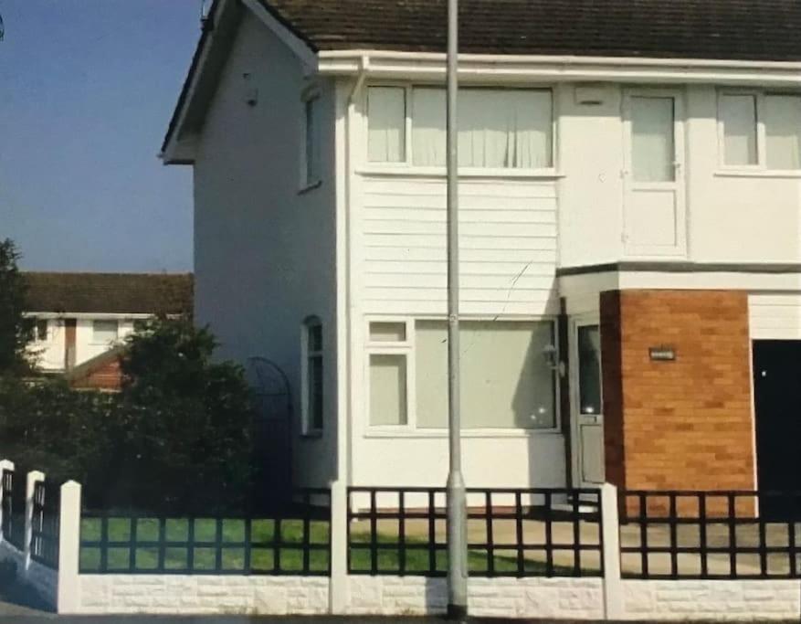 une maison blanche avec une clôture devant elle dans l'établissement Spacious three bedroom property in Penrhyn bay - sleeps 6, à Penrhyn Bay