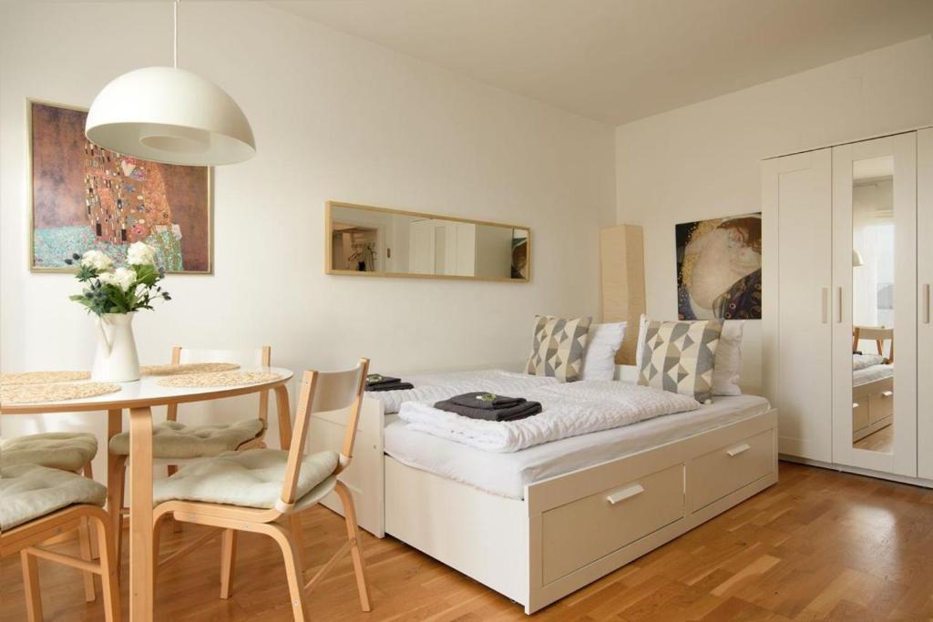 1 dormitorio con cama, mesa y comedor en Modern Vienna Apartment in Prime Location, en Viena