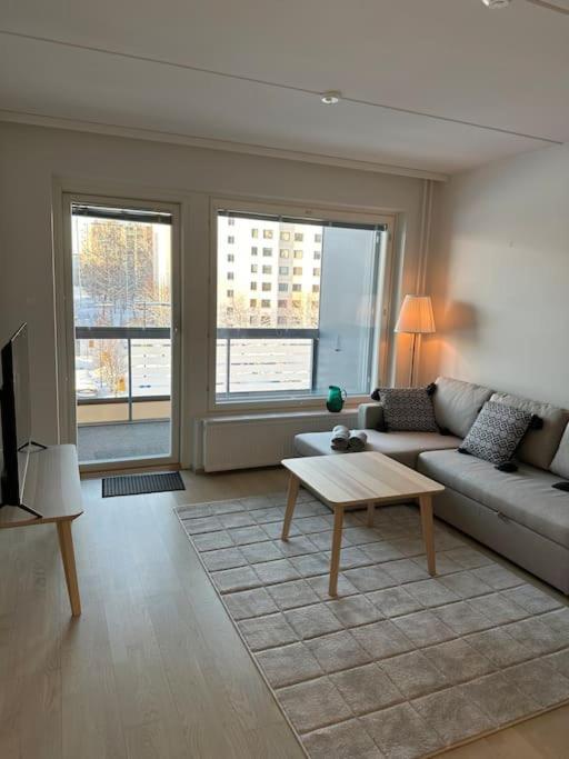 een woonkamer met een bank en een salontafel bij Kaikki palvelut aivan vieressä in Helsinki