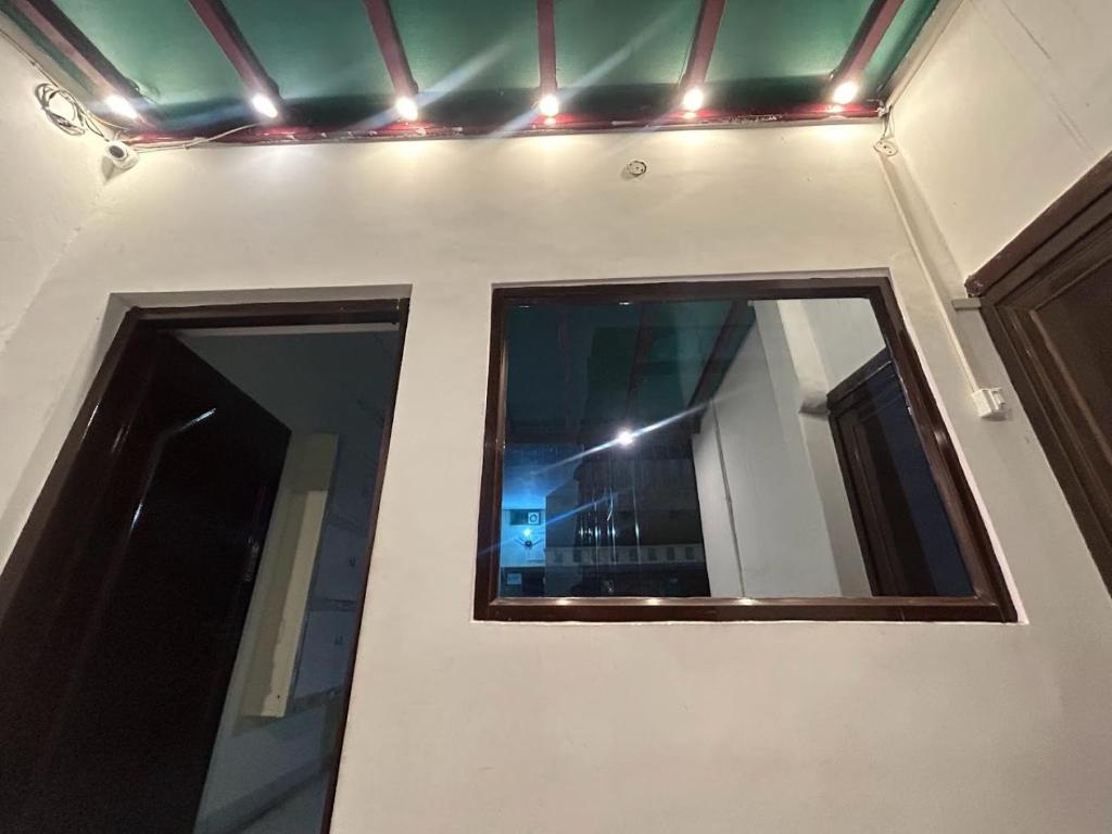 a room with two windows and lights on the wall at The Darsya Varanasi in Varanasi