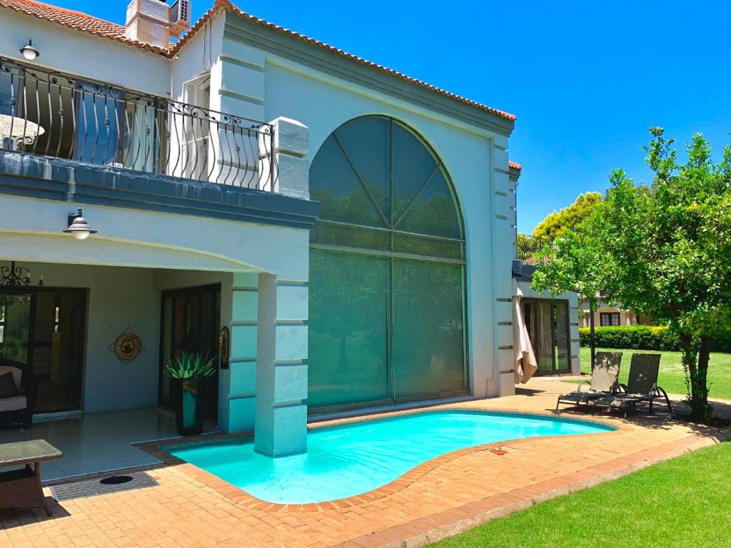 a swimming pool in front of a house at Westlake Waterfront Villa - Entire Villa in Hartbeespoort