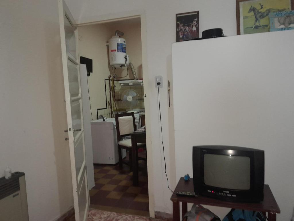 a living room with a television and a room with a table at El rosal ,descanso para viajeros in Junín