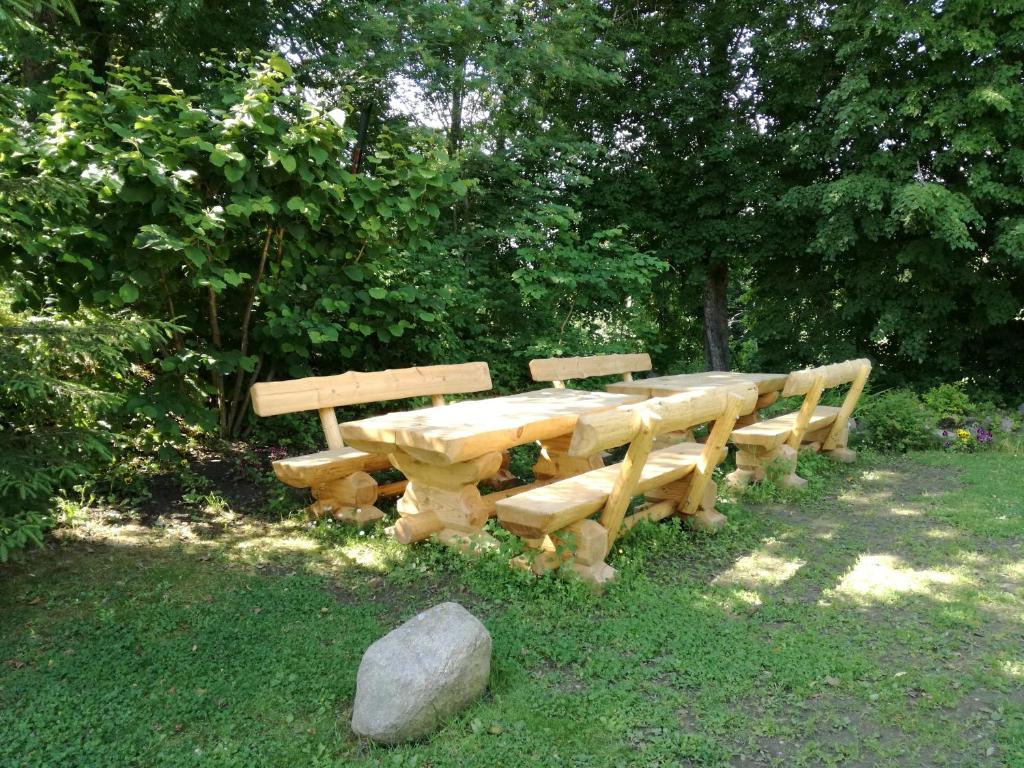 a wooden table and benches in the grass at Villa River Rose in Jõesuu