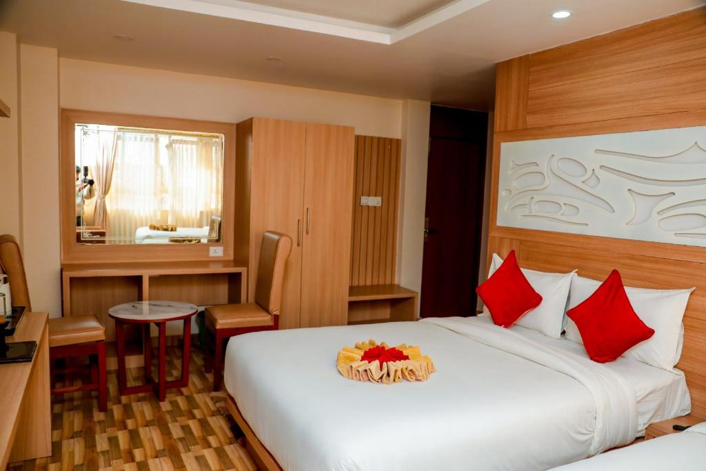 a hotel room with a large bed with red pillows at Hotel Kedarnath in Kathmandu