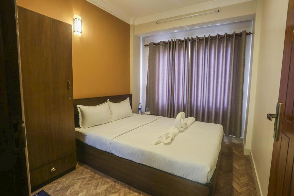 Un dormitorio con una cama con una toalla. en Paradise Guest House, en Katmandú