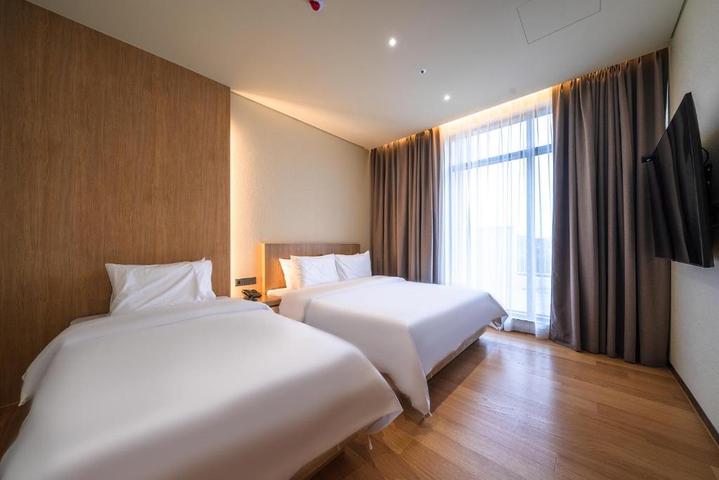 Postel nebo postele na pokoji v ubytování Uiwang Milos Hotel