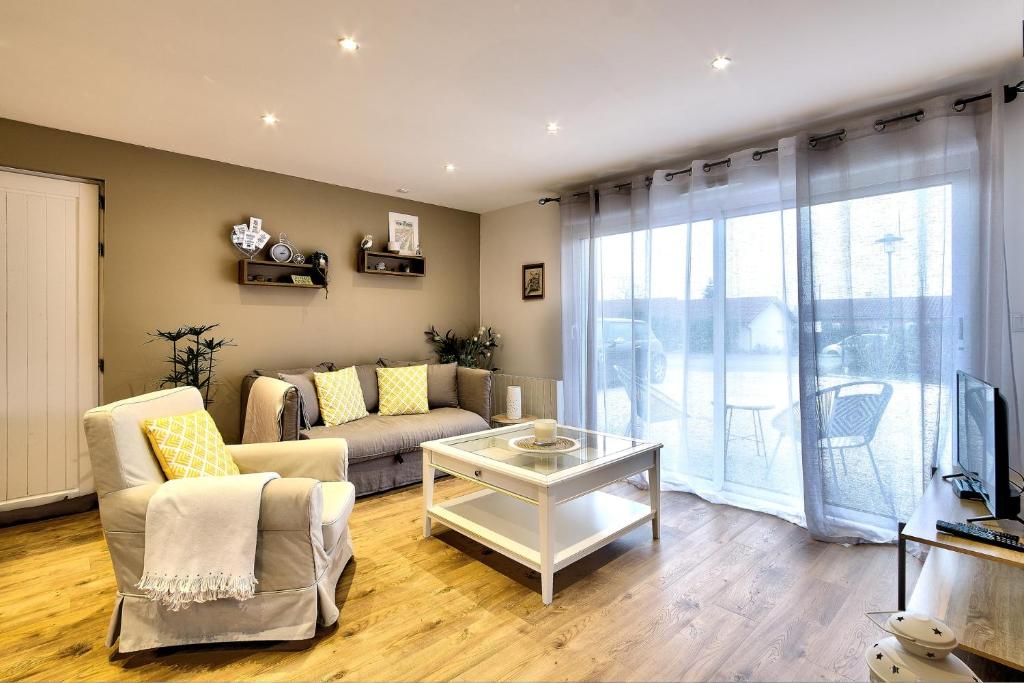 a living room with a couch and a table at Au coeur des 3 bâgé in Bâgé-la-Ville