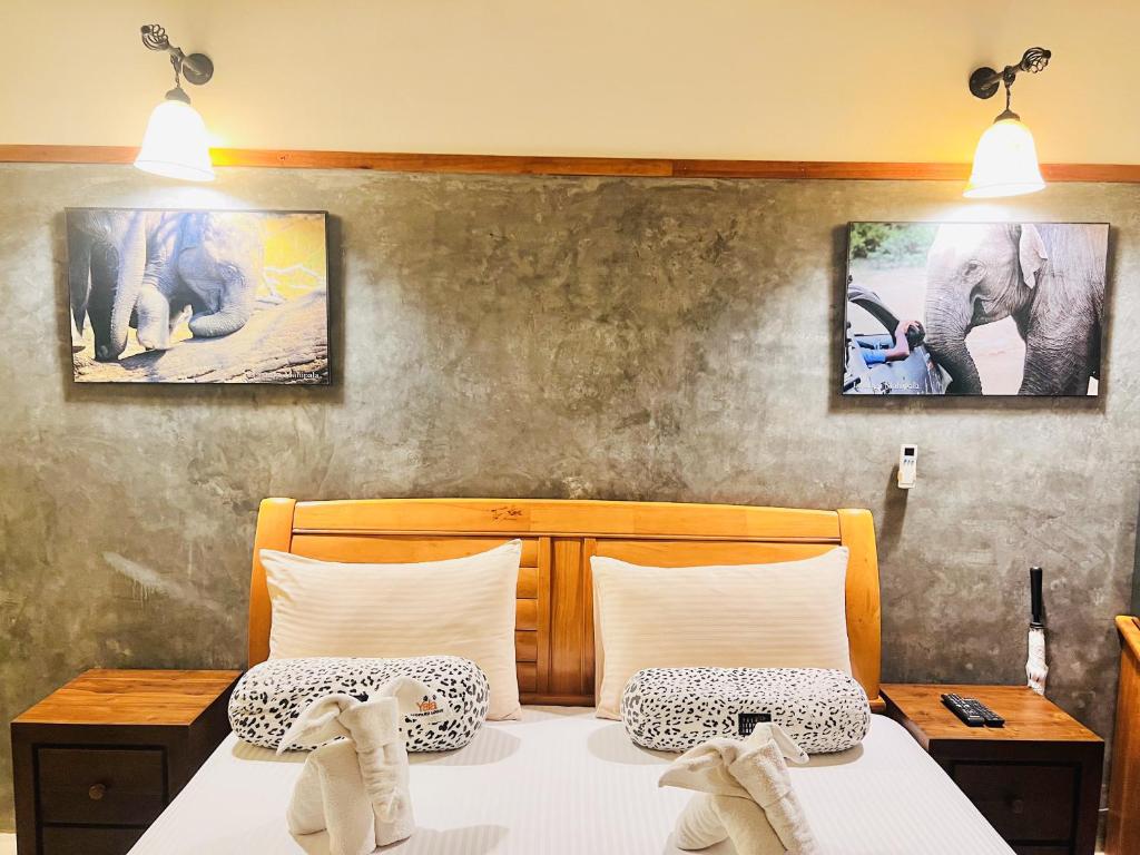 ヤーラにあるYala Leopard Lodgeのベッドルーム1室(ベッド2台付)が備わります。壁に2枚の写真が飾られています。
