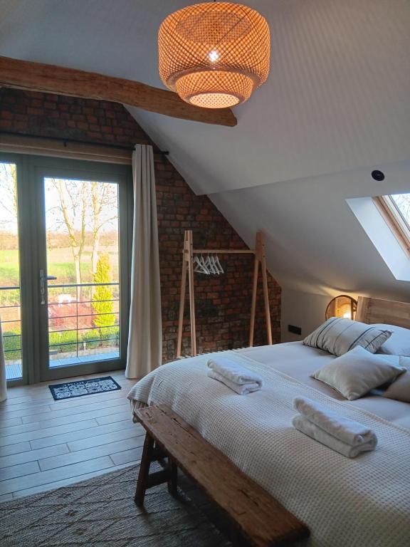 um quarto com uma cama e uma grande janela em La chambre des daines em Binche