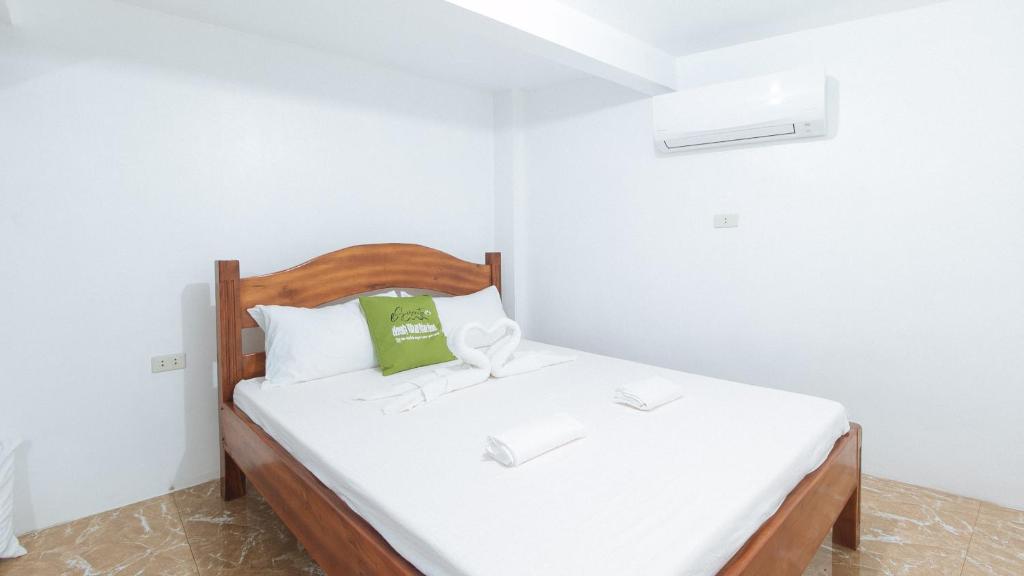 małą sypialnię z łóżkiem z zieloną poduszką w obiekcie ESerenty Private Villa Pangasinan by RedDoorz w mieście Banaybayan