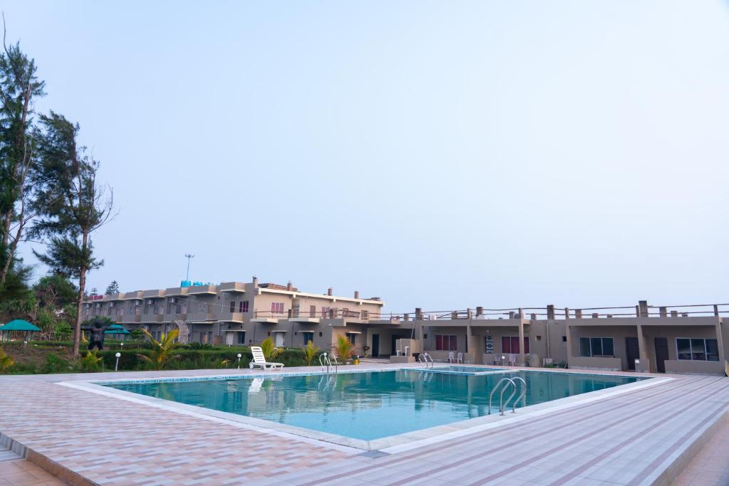 una grande piscina di fronte a un edificio di Hotel Nilkantha a Mandarmoni