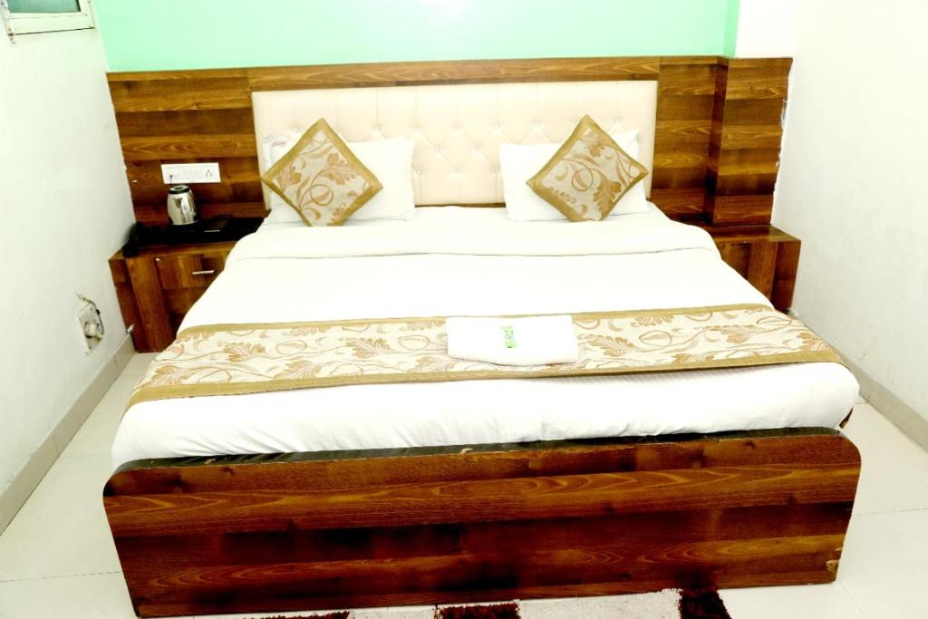 a bedroom with a bed with a wooden headboard at Hotel India international Deluxe in New Delhi
