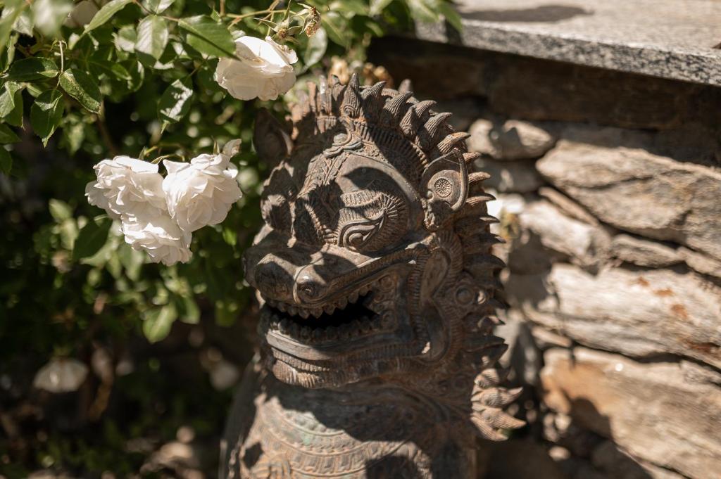 Una estatua de una cabeza con flores blancas. en Oberortlhof - Juval, en Castelbello