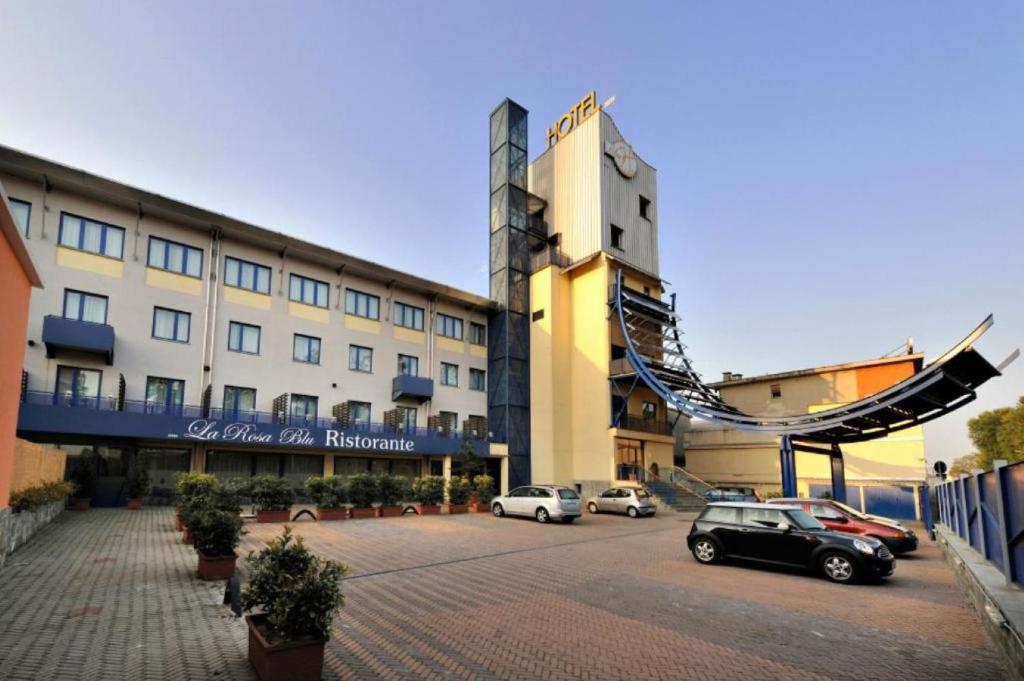 duży budynek z samochodami zaparkowanymi na parkingu w obiekcie Blu Hotel - Sure Hotel Collection by Best Western w mieście Collegno