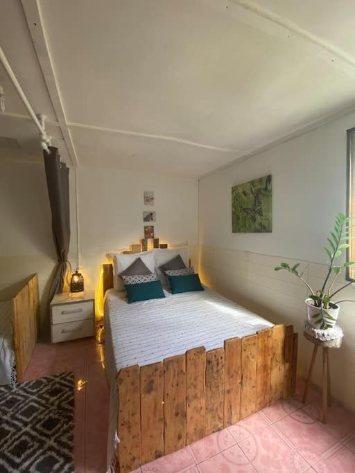 - une chambre avec un lit en bois dans l&#39;établissement Ptite case Fantaisie, à Saint-André