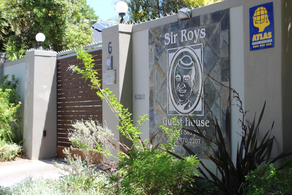 een bord voor een huis met een trap bij Sir Roys Guest House in Port Elizabeth