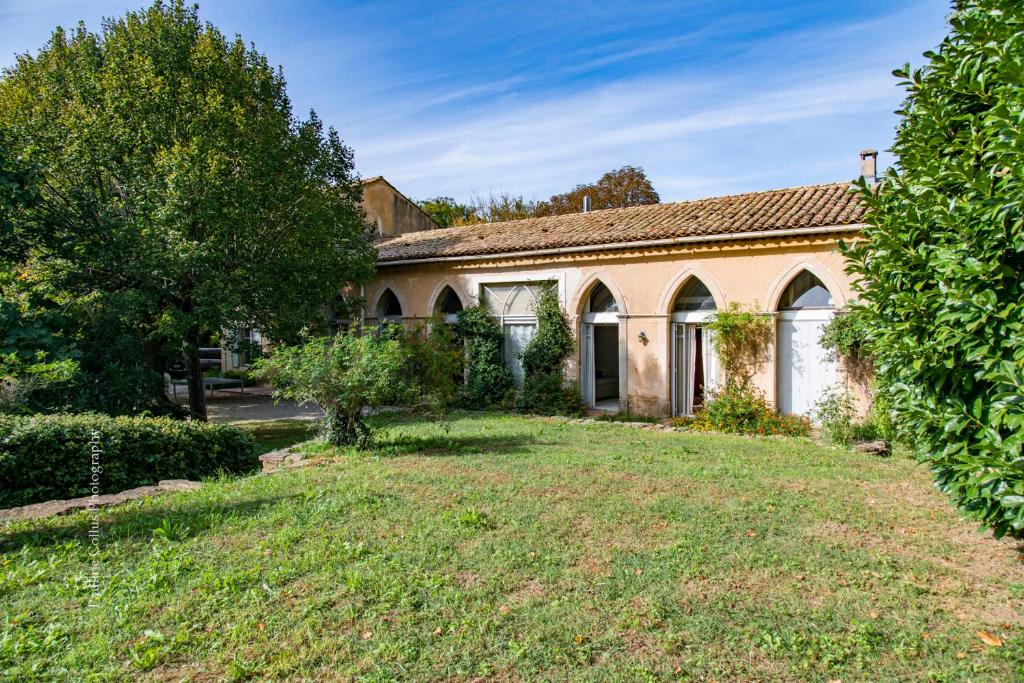 an old stone house with a yard at La Magnanerie, 16 personnes avec piscine privée in Bagnols-sur-Cèze