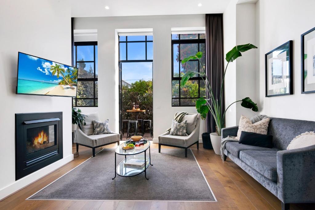 een woonkamer met een bank en een open haard bij Heritage Luxury Apartment-Footy & CBD in Geelong