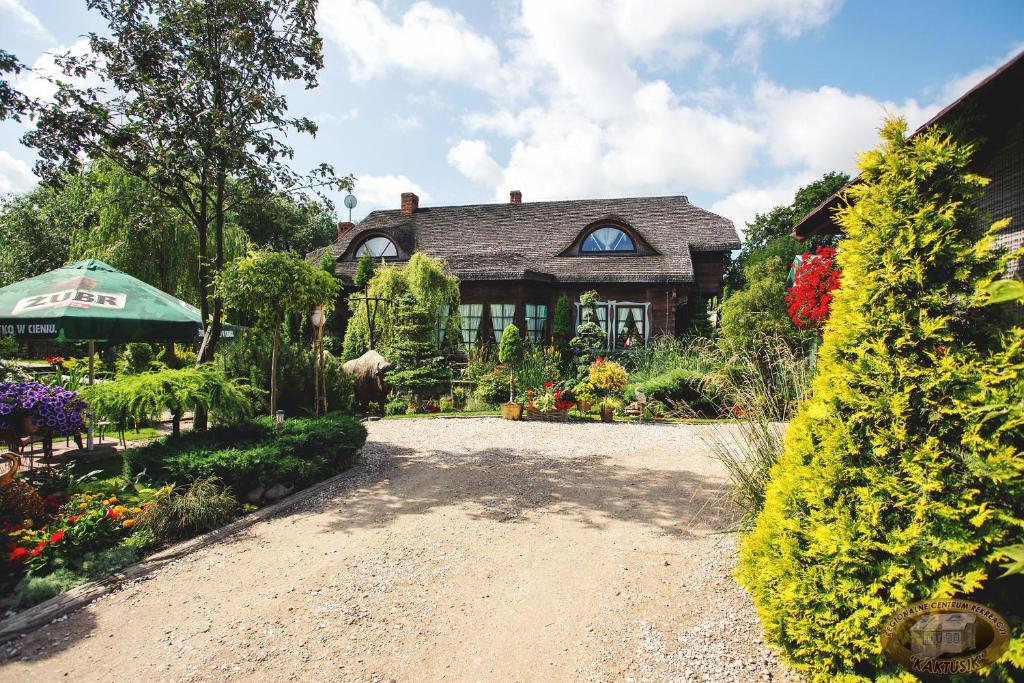 a house with a garden and a gravel driveway at Kaktusik in Augustów