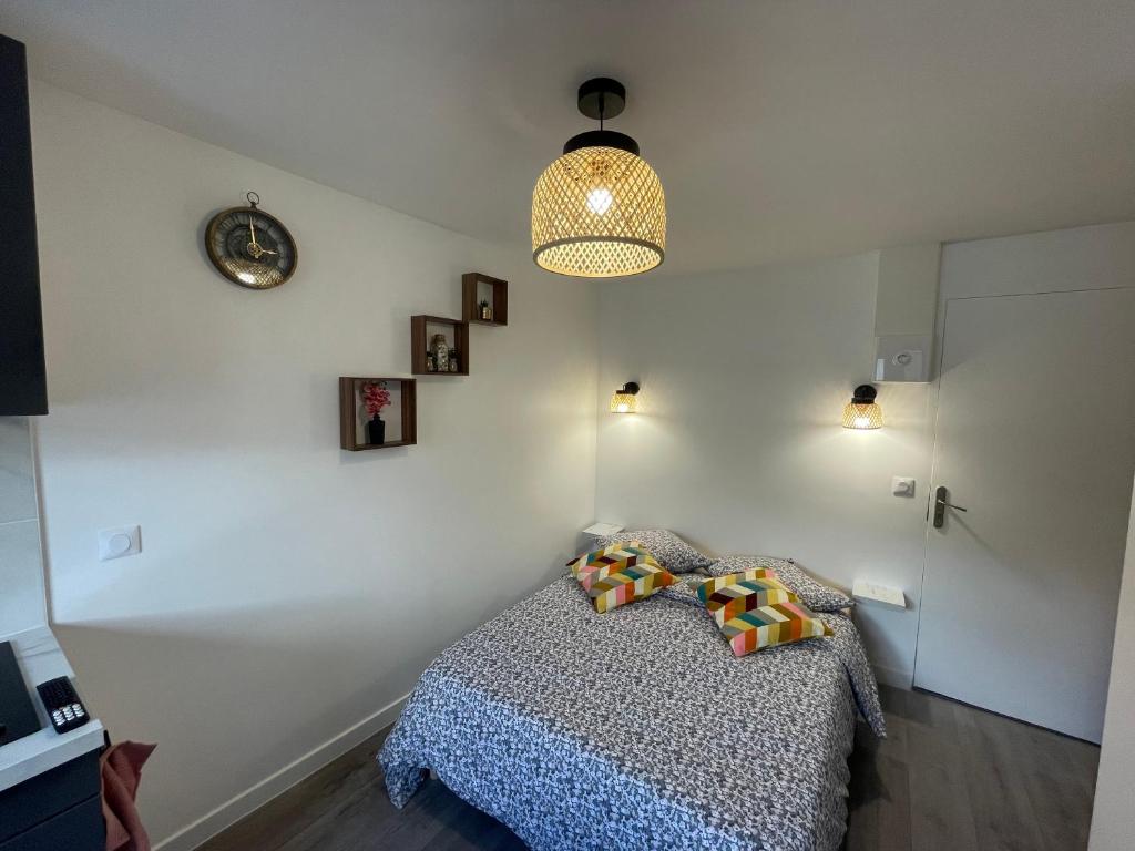 a bedroom with a bed with two pillows on it at studio 9 neuf et moderne in Tremblay-En-France