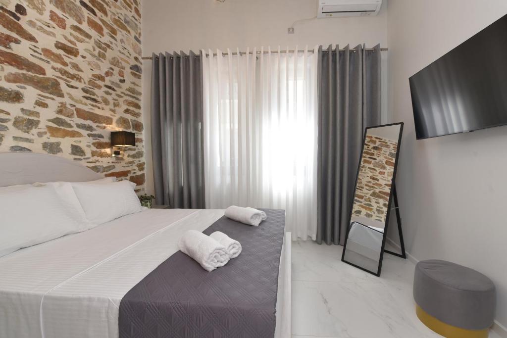 a bedroom with a bed with two towels on it at Alesio's house in Ermoupoli
