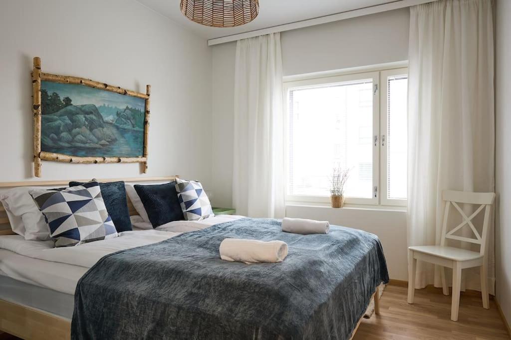 a bedroom with a bed and a window and a chair at Saunallinen uudiskohde Logomon vieressä, ilmainen autohallipaikka + Wi-Fi in Turku