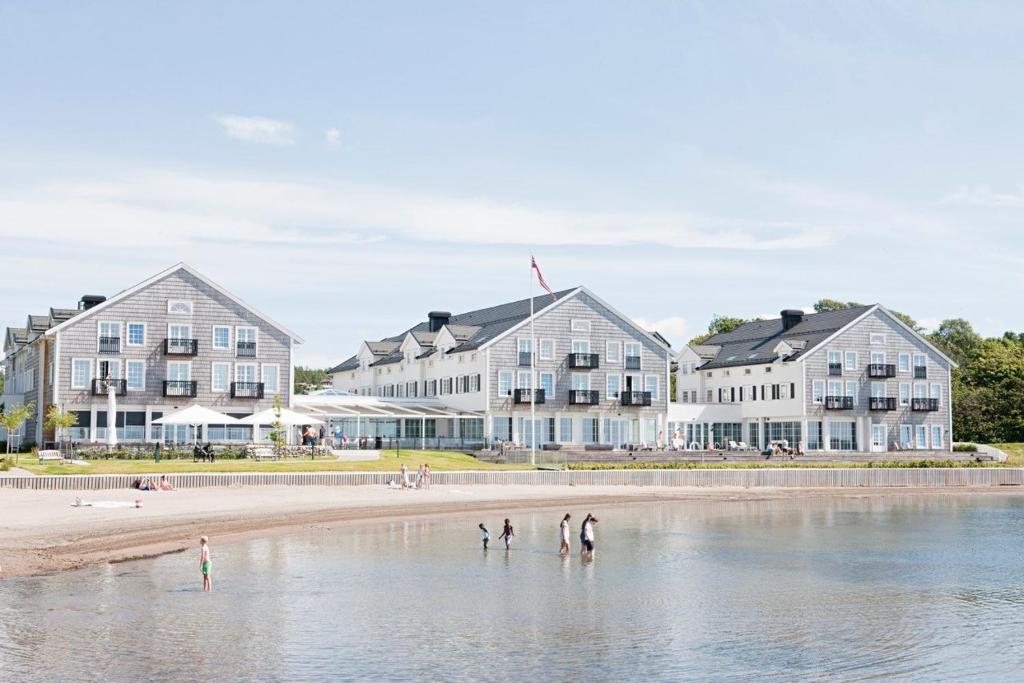 un groupe de personnes debout dans l'eau devant un bâtiment dans l'établissement Støtvig Hotel, à Moss