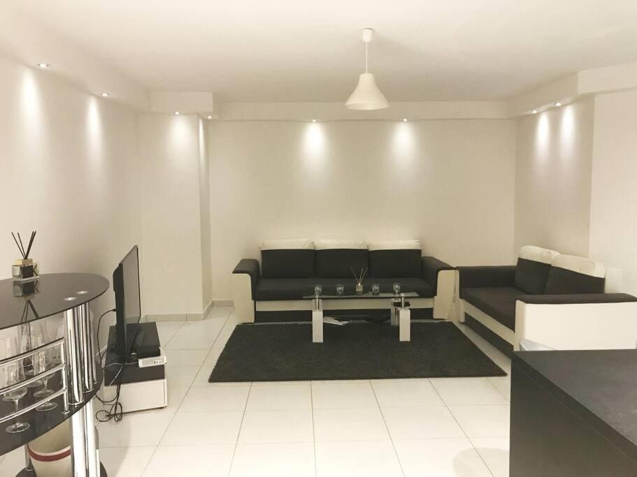 a living room with a couch and a table at Logement à Tassin avec piscine et garage in Tassin-la-Demi-Lune