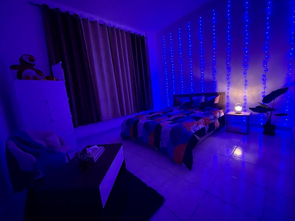 Dormitorio púrpura con cama y mesa en Stress-Free Cozy Private Room - heart of the city, en Abu Dabi