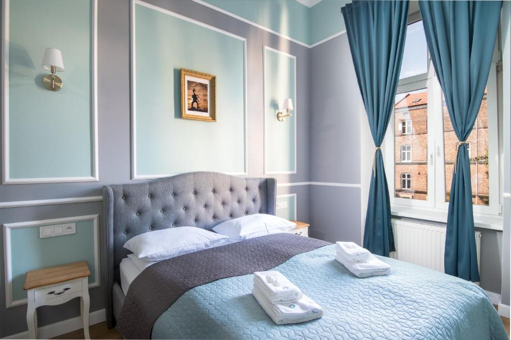 una camera da letto con un letto e due asciugamani di Karmelicka Stylish Apartments in Cracow by Renters a Cracovia