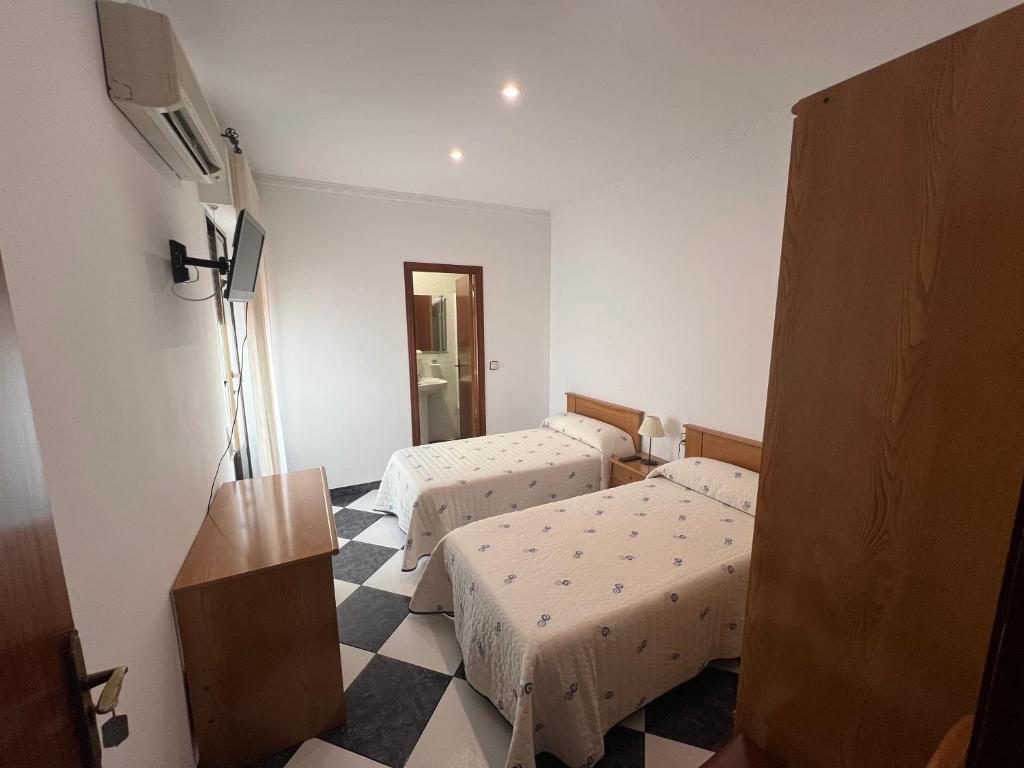 Ένα ή περισσότερα κρεβάτια σε δωμάτιο στο Hostal Los Amigos